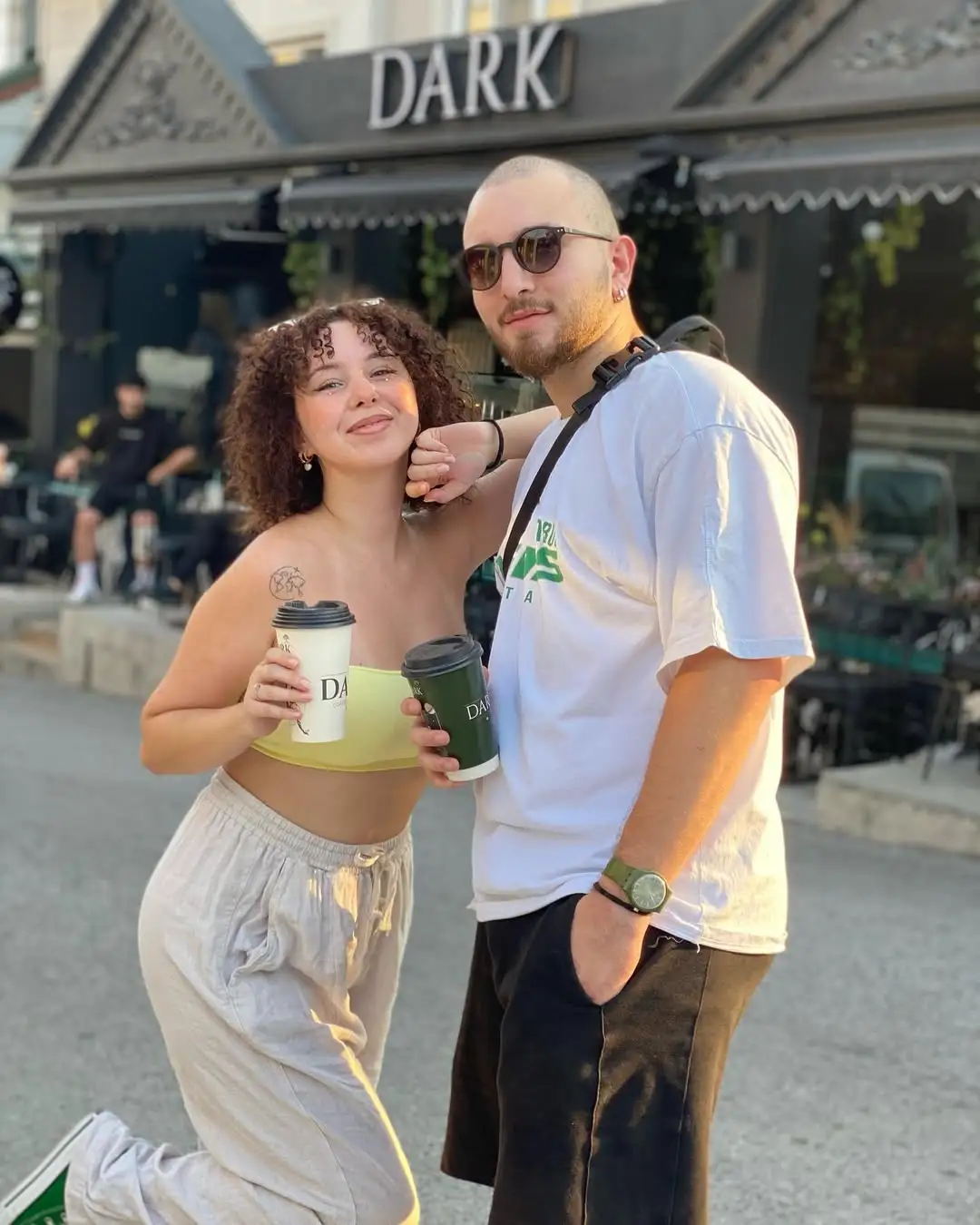 Dark Coffee Factory önünde kahveyle poz veren misafirler